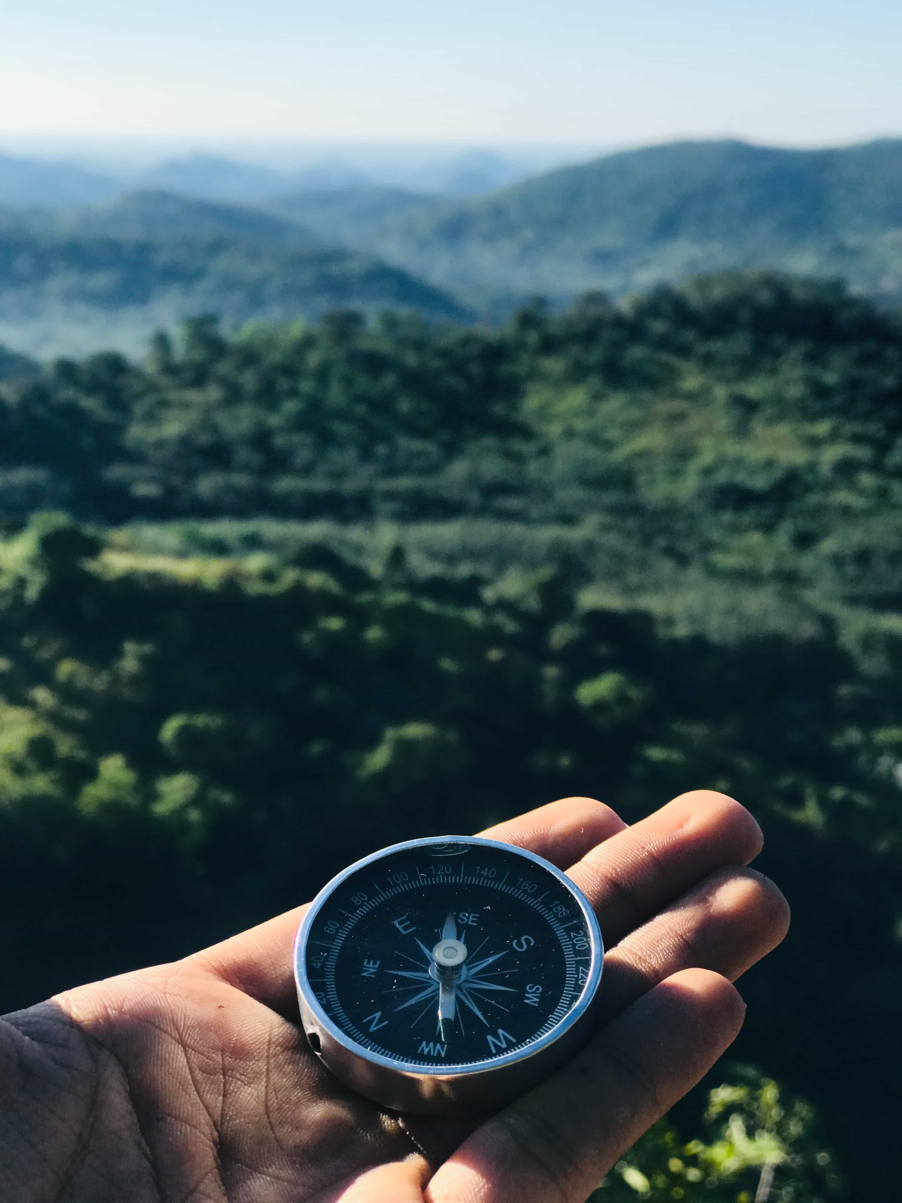 Person holding compass in an Alpine valley
