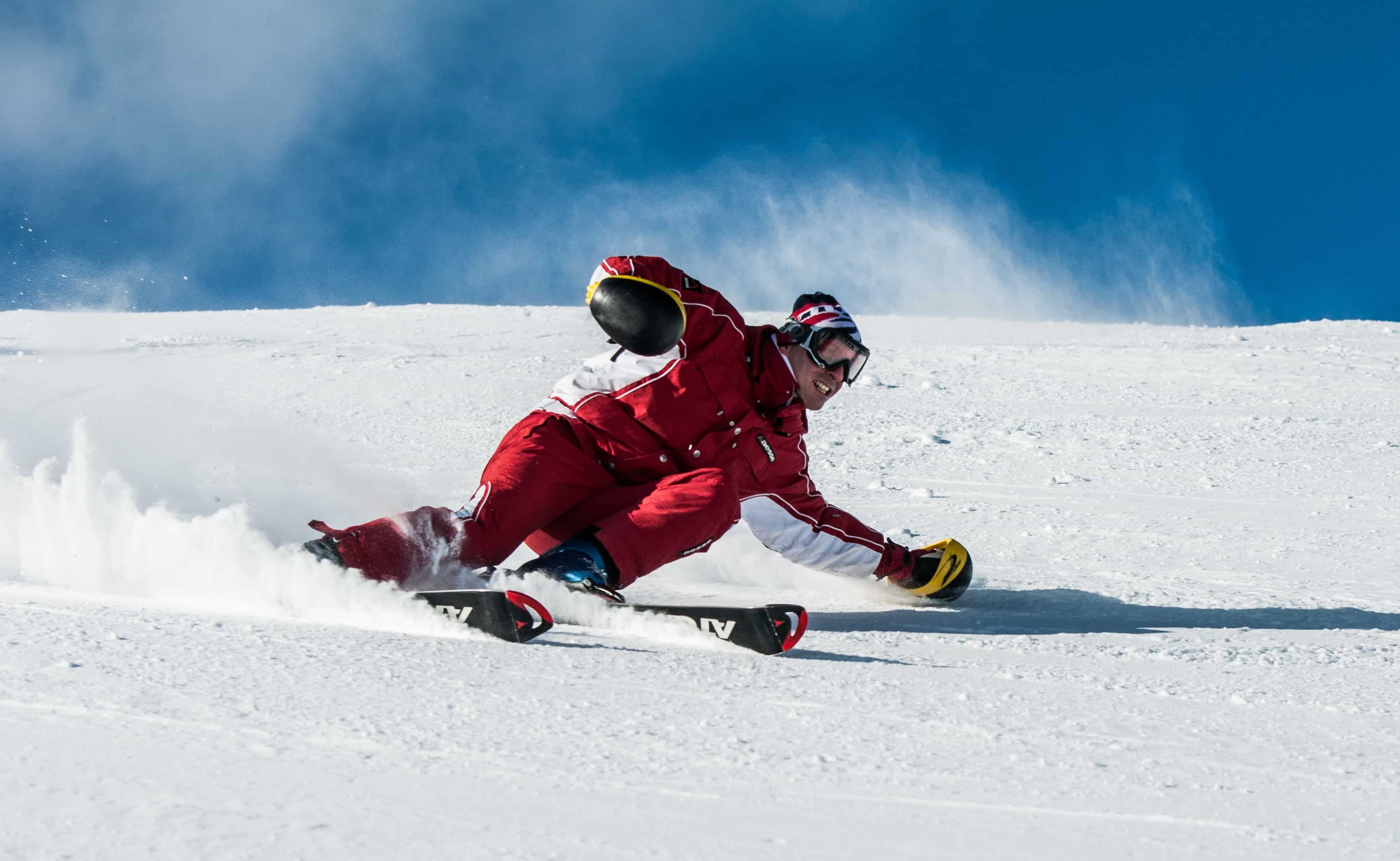 Man in red skiing down a slope